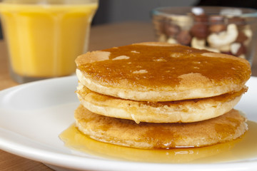 Close up of a stack of pancakes covered in syrup