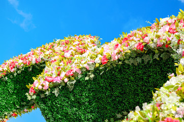 Beautiful flower installation on background of blue sky with clouds.  
