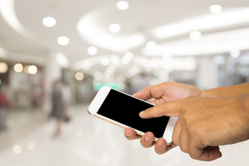 Hand hold smartphone on blur shopping mall
