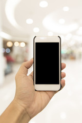 Hand hold smartphone on blur shopping mall