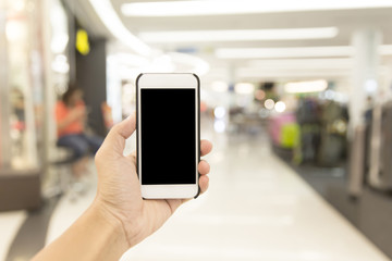 Hand hold smartphone on blur shopping mall