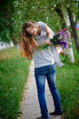 beautiful woman with a bouquet of lupine on the man's shoulder