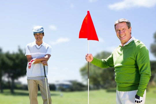 Composite image of men holding a golf club