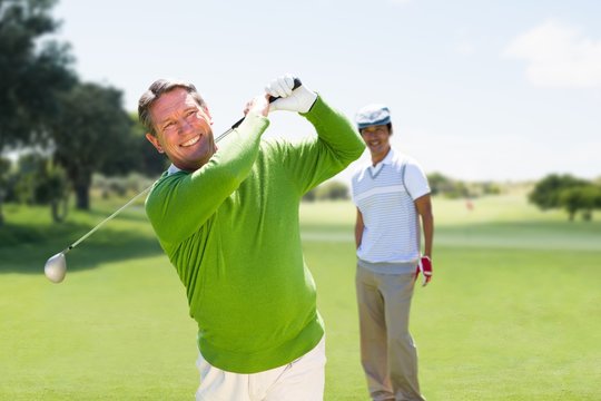 Composite image of man playing golf