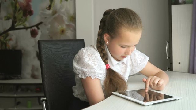 Primary schoolgirl using a digital tablet computer