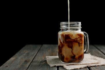 Jar of iced coffee on wooden table