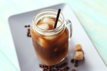 Glass jar of iced coffee on tray