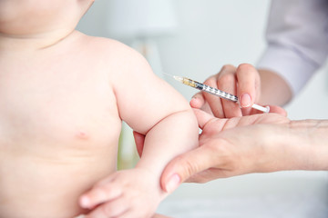 Professional pediatrician vaccinating baby, close up