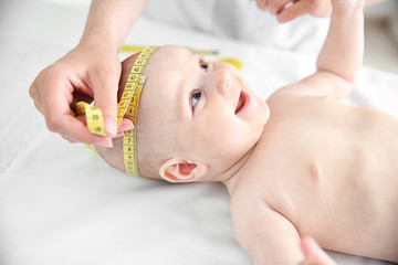 Obraz na płótnie Canvas Professional pediatrician examining smiling baby
