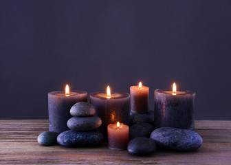 Obraz na płótnie Canvas Spa stones with burning candles on grey background