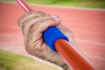 Composite image of close-up of hand holding javelin