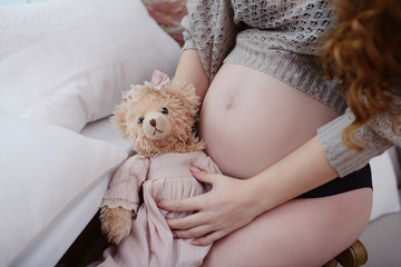 Beauty pregnant woman indoors. Female portrait of cute lady. Close-up beautiful model girl in elegant pose