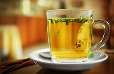 Glass cup of fresh green tea on blurred kitchen background
