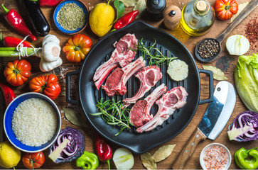 Ingredients for cooking healthy meat dinner. Raw uncooked lamb chops in iron grill pan with...
