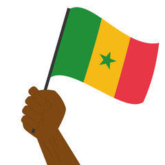 Hand holding and raising the national flag of Senegal