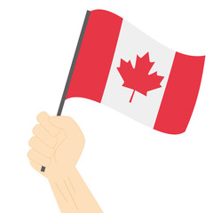 Fototapeta na wymiar Hand holding and raising the national flag of Canada