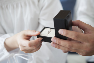 Men are passing a diamond ring on woman