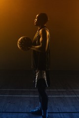 Side view of a basketball player holding a basketball