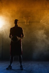 Fototapeta premium Portrait of a basketball player holding a ball in his hands