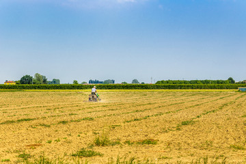 Fototapeta premium small tractor plowing a large field