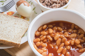 Baked beans in tomato sauce on bowl with bread and tuna steak