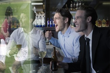 Composite image of handsome friends having a drink together