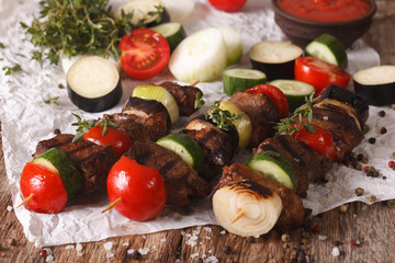 Meat with vegetables on skewers close-up on the table. Horizontal
