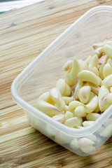 Pile of peeled garlic on wooden table