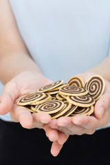 Pile of pinwheel chocolate cookie in an asian woman's hand