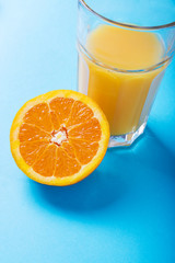 Glass of orange juice and half of orange