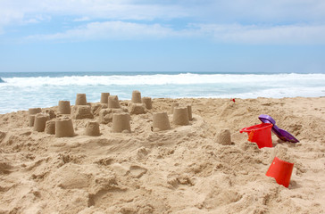 Sandcastle on the beach with toy bucket and shovel
