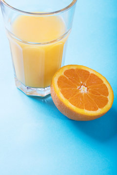 Glass of orange juice and half of orange