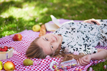 Beautiful young woman having picnic in park