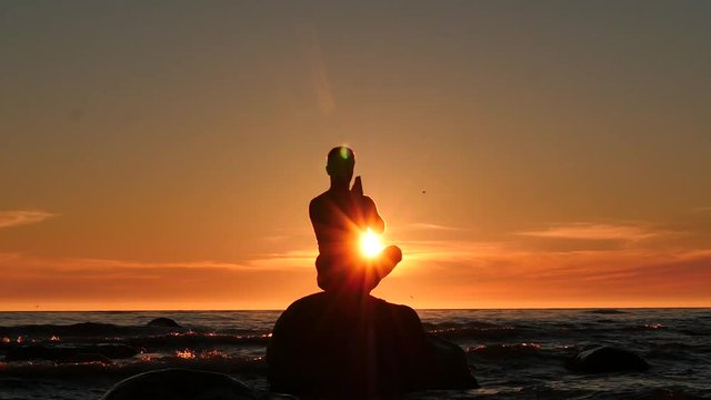 man prayer and worship to sun in the island on waving sea dolly shot