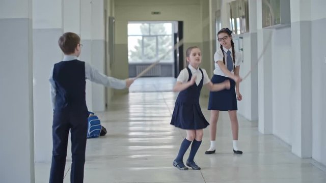 Cute girl jumping rope at school break in slow motion but stumbling and stopping 