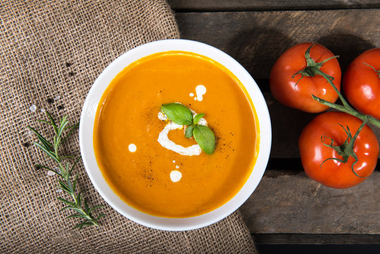Tomato squash soup with basil leaf and sour cream