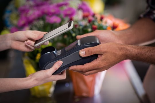 Hand of customer making payment through smartphone