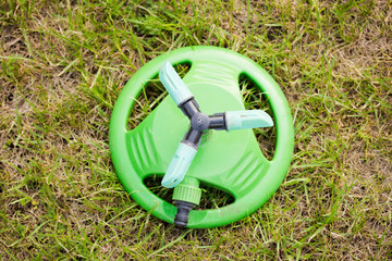 garden sprayer with a hose lying on the grass