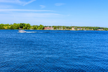 Small open motorboat traveling in the Swedish archipelago of Vastervik on a fine summer day.