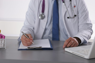 Male doctor write on the desk with test tube