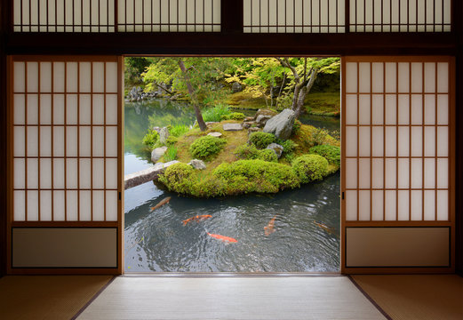 Sliding Japanese doors and fish pond with colorful orange carp swimming in the water