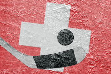 Naklejka premium The image of the Swiss flag and hockey puck with a stick