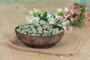 Herbal pill on wooden bowl. herb for healthy living.