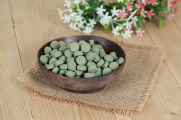 Obraz na płótnie Canvas Herbal pill on wooden bowl. herb for healthy living.