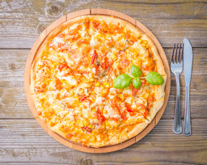 Tasty delicious pizza on the wooden table.