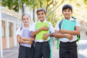 Portrait of smiling school kids standing in campus