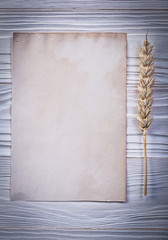 Wheat ear blank vintage paper sheet on wooden board directly abo