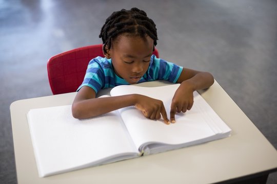 School boy memorizing the lesson in classroom