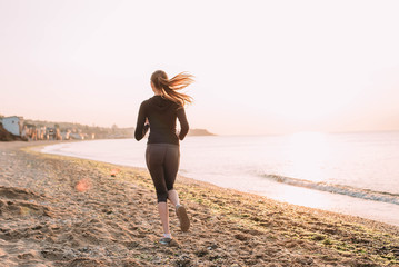 Running woman. Female runner jogging during the sunrise on beach.