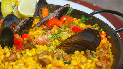 Frische Paella mit Meeresfrüchten und Hühnerbrust garniert in einer Pfanne